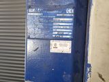 an image of a blue and white refrigerator in front of a garage door