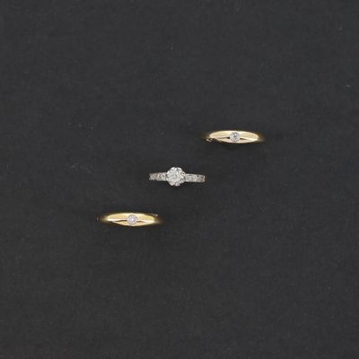 trois bagues en or et diamants sur un fond noir