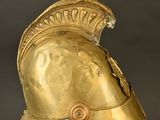 a close up of a gold helmet on a clear stand