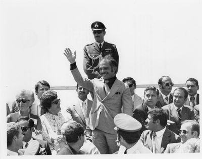 une vieille photo en noir et blanc montrant un homme en uniforme militaire faisant signe à une foule de personnes