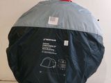 un sac noir et bleu muni d'une poignée rouge, posé sur une surface blanche