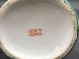 a close up of a white and green bowl on a table
