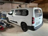 a van that is parked in a garage with tools on the floor