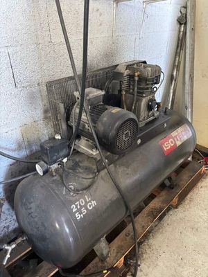 deux compresseurs d'air posés sur une palette dans un garage