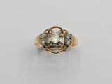 a gold ring with a white diamond and two smaller diamonds