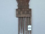 un peigne en bois sur lequel a été sculpté un motif