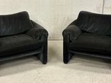pair of black leather club chairs with arms and legs