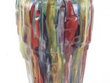 un vase multicolore posé sur une surface blanche