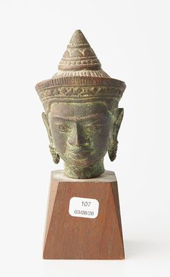 une image représentant une statue d'une tête posée sur un socle en bois