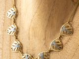 gold and blue geometric necklace on a mannequin mannequin mannequin mannequin mannequin mannequin mannequin mannequin mann