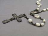 rosary with a crucifix and a cross on a gray surface
