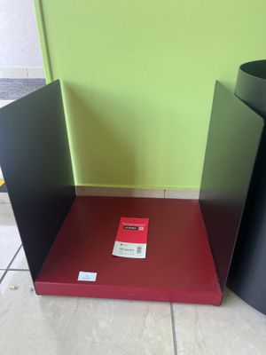 deux poubelles noires et rouges posées par terre l'une à côté de l'autre