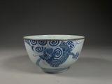 blue and white bowl with a dragon design on the side