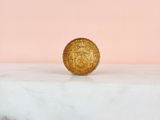 a gold coin sitting on top of a marble counter top