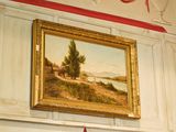 un tableau accroché au mur au-dessus d'une borne d'incendie rouge