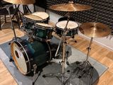 a drum set up in front of a sound wall