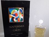 un flacon de parfum posé sur une table à côté d'un livre
