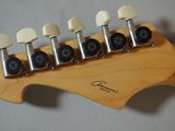 a close up of a guitar neck with six knobs