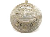 une image représentant une assiette en argent sur laquelle figure l'image d'un bateau