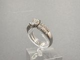 une photo d'une bague en diamant posée sur un socle transparent