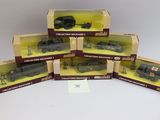 six petits trains miniatures emballés dans leurs boîtes, posés sur une surface blanche