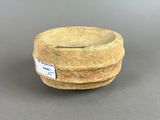 an image of a small stone bowl with a label on it