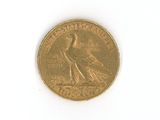 a gold coin with a bird on it on a white surface