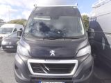 une camionnette noire garée sur un parking à côté d'autres voitures
