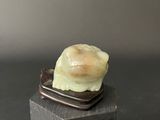 a figurine of a snail sitting on top of a wooden block