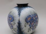 un vase bleu et blanc posé sur une surface blanche