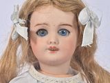 a close up of a doll with blue eyes and blonde hair