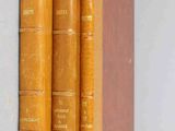 three books are stacked on top of each other on a shelf