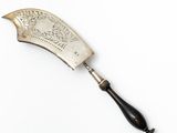 a silver plated knife with a black handle on a white surface