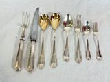 a lot of silverware on a table with a knife and fork