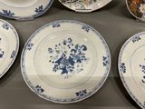 many plates with blue flowers on them on a table