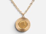 un collier en or avec une pièce de monnaie sur une chaîne