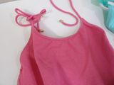 a pink tank top with a knot on the front