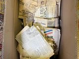 a cardboard box filled with old newspapers and other papers