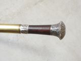 a close up of a metal and wood cane with a wooden handle