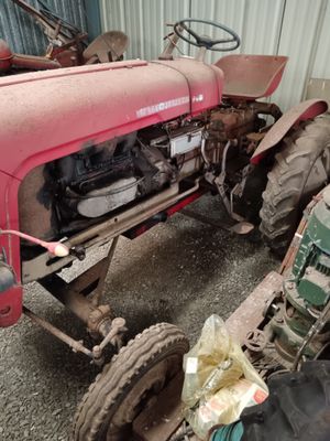 a red tractor that is parked in a garage