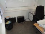 a desk with a chair and a printer in a small room
