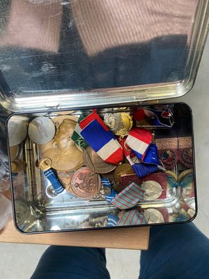 someone is holding a suitcase full of assorted items on a table
