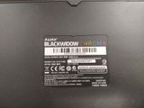 the back of a black laptop with a barcode on it