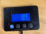 a digital clock on a table with a charger