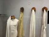 trois mannequins accrochés au mur dans une salle de bains