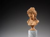 un buste sculpté représentant une femme, posé sur un socle en marbre