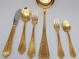 a gold plate with a spoon, fork, and knife on it