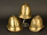 three gold helmets are sitting next to each other on a black surface