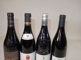four bottles of wine are lined up on a table