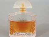 an image of a bottle of perfume sitting on top of a table